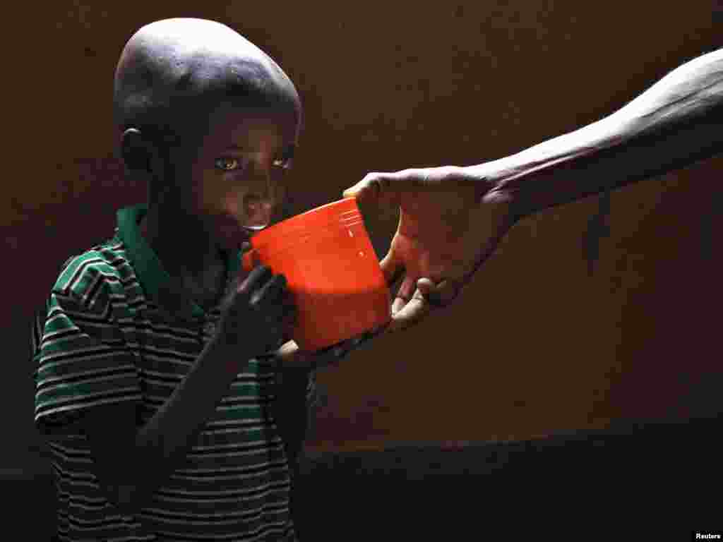 Severely malnourished Sadiki Basilaki, 9, receives a mug of milk at a catholic mission feeding center in Rutshuru, 70kms (50 miles) north of Goma in eastern Congo, November 13, 2008. Malnutrition rates in Rutshuru, which has seen weeks of fighting between government soldiers and dissident Tutsi general Laurent Nkunda's rebels, are almost double emergency thresholds and aid workers are battling insecurity to deliver rations. The latest wave of fighting has worsened a humanitarian disaster that began in the 1990s. REUTERS/Finbarr O'Reilly 