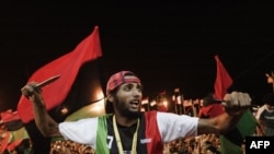 Повстанцы празднуют арест сына ливийского лидера Муаммара Каддафи и частичное взятие столицы Триполи. Бенгази, 21 августа 2011 года.