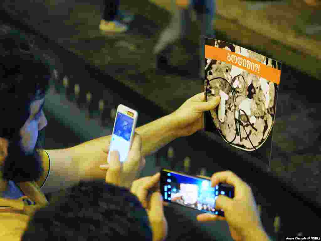 Protesters hold up pictures of a medical scan, which they say is of an activist&#39;s skull in which a rubber bullet is embedded.