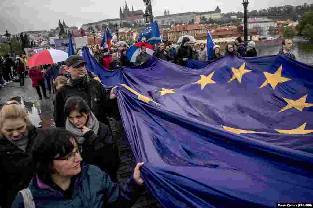 Протестувальники з прапором Європейського Союзу йдуть ходою через Карлів міст у Празі, протестуючи проти уряду прем&rsquo;єр-міністра Чехії Бабіша