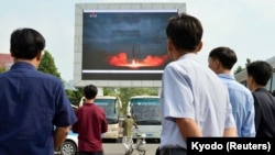 Люди смотрят репортаж о запуске баллистической ракеты «Хвасон-12». Пхеньян, КНДР, 30 августа 2017 года