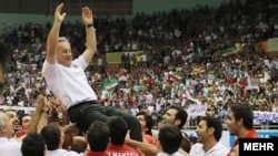 Иранские волейболисты подбрасывают своего тренера после получения места в международном турнире по волейболу после победы над сборной Японии. 9 сентября 2012 года.