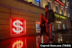 Прохожие около электронного табло с курсами обмена валют в Санкт-Петербурге. Россия, архивное фото