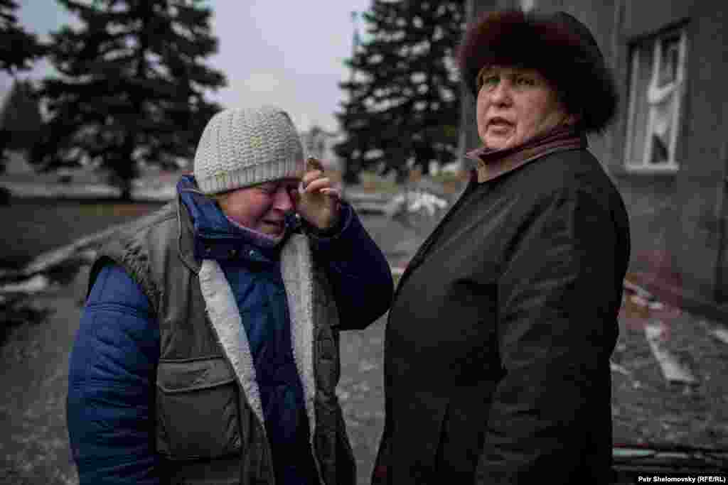 A woman cries in front of the destroyed city council building.