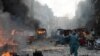 A Pakistani man runs past burning vehicles at the site of twin bomb explosions at the busy Kissa Khwani market in Peshawar on September 29, 2013. 