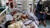 AFGHANISTAN -- A woman (R) sits next to newborn babies who lost their mothers following a suicide attack in a maternity hospital, in Kabul, May 13, 2020