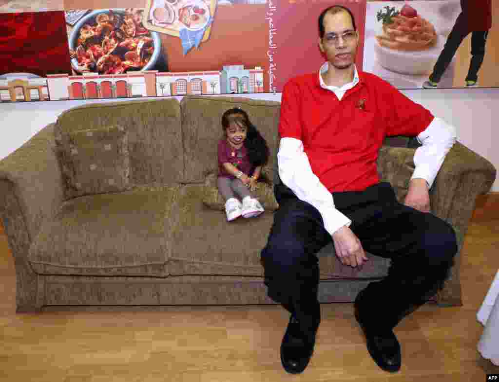 Indian Jyoti Amge, 19, the world&#39;s shortest woman, sits next to Morocco&#39;s Brahim Takioullah, who has the largest feet in the world, according to the Guinness Book of Records, during an event in Kuwait City. Amge and Takioullah are in Kuwait as part of a competition organized by the Guinness Book of Records. (AFP/Yasser Al-Zayyat)