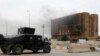 Smoke from previous clashes with Islamic State militants rises from a building near an Iraqi security forces military vehicle during an intensive security deployment in Ramadi, west of Baghdad, in December.