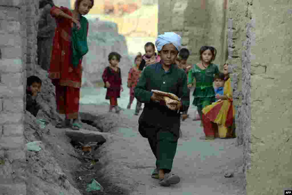 An Afghan boy carries bread for iftar, the meal that breaks the daily fast during the Muslim holy month of Ramadan, on the outskirts of Jalalabad. (AFP/Noorullah Shirzada)