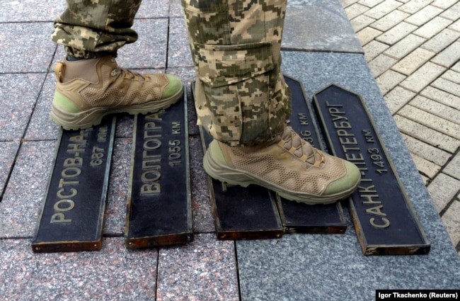 A Ukrainian soldier steps on signs that used to point in the direction of Russian cities that were removed from use in Odesa amid Moscow's invasion of Ukraine on April 14.