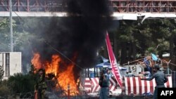 Afghan security forces shout as they keep watch at the site of a huge blast that struck the entrance to Kabul airport on August 10.