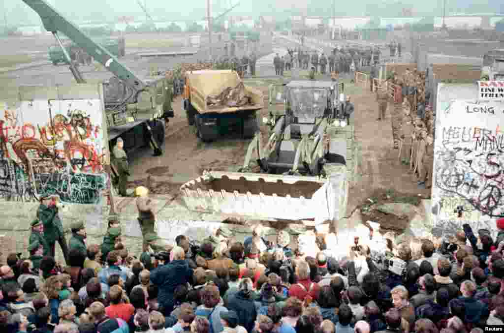 An East German bulldozer and crane knock down the Berlin Wall at Potsdamer Platz to make way for a new border crossing on&nbsp;November 12, 1989. Усходненямецкі бульдозэр і кран разьбіраюць Бэрлінскі мур каля Патсдамскай плошчы, каб зрабіць новы памежны пераход, 12 лістапада 1989. 