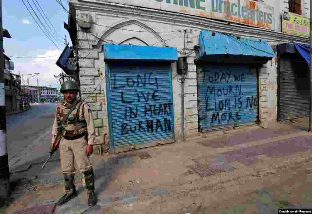 An Indian policeman alongside graffiti in Kashmir proclaiming support for an Islamist militant who was killed by Indian security forces in July 2016. Kashmir is a disputed region that is the main source of friction between India and Pakistan.