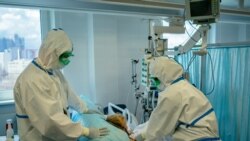 Дәрігерлер коронавирус диагнозы қойылған науқасқа көмек көрсетіп жатыр. Көрнекі сурет.