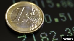 Italy -- A picture illustration shows a one euro coin on a flat screen displaying exchange rates in Rome, 08Dec2011