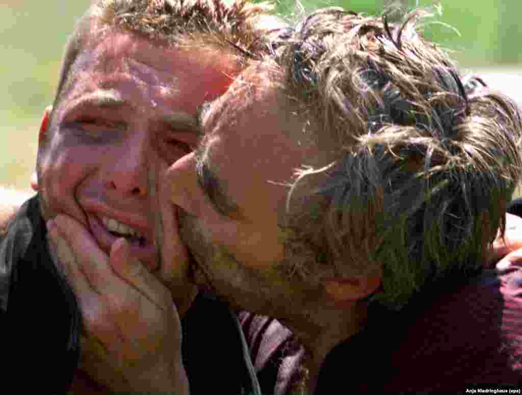 Kosovo Albanian refugees, released by Serb forces, are lost in tears as they kiss each other after reaching a checkpoint in Morina, Albania, on June 5, 1999.