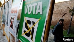 Мужчина проходит мимо плакатов, на лицевой стороне которых перечеркнута надпись: «Да». Плакаты размещены в Риме накануне референдума в Италии. 30 ноября 2016 года.