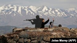 Tourists stand next to a silhouette sculpture of an Israeli soldier at an army post on Mount Bental in the Israeli-annexed Golan Heights.