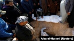 Mourners gather around the body of a demonstrator who was killed at an anti-government protest overnight, during a funeral in Najaf on February 6.