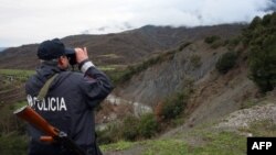 Një polic i Shqipërisë duke e vëzhguar kufirin me Greqinë