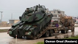 Un tanc al Armatei Turciei este descărcat la o bază militară din orașul Reyhanli în provincia Hatay, în apropiere de granița turco-siriană, ianuarie 2018.
