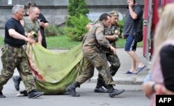 Separatiști cărând trupul unui tovarăș ucis.