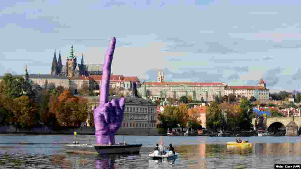 A sculpture by Czech artist David Cerny floats in the Vltava River in Prague on October 21, shortly before the country&#39;s general elections. The giant purple middle finger is directed toward the Prague Castle, the seat of Czech President Milos Zeman.