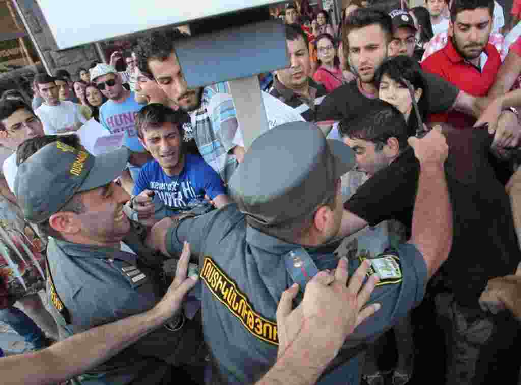 Armenian riot police confront youth activists protesting against higher bus fares in Yerevan on July 22. (RFE/RL/Emil Danielyan)