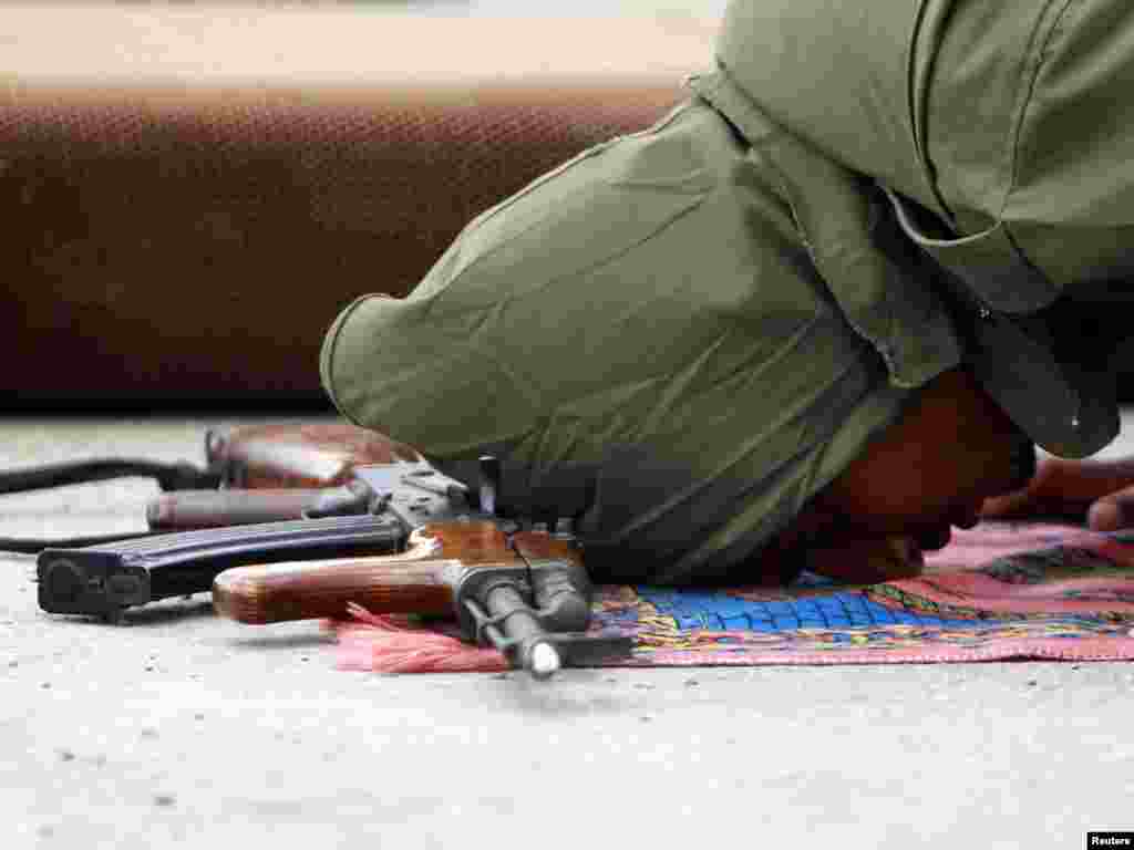 A Libyan rebel fighter prays beside his weapon at the front line along the western entrance of Ajdabiyah. Photo by Amr Abdallah Dalsh for Reuters.