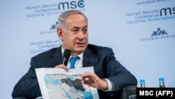 Israeli Prime Minister Benjamin Netanyahu shows a map of the Middle East during a panel discussion at the Munich Security Conference in Munich, February 18, 2018