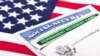 Картка сацыяльнага страхаваньня і Green Card на тле сьцягу ЗША