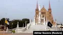 Знамињата на Ватикан и на Пакистан пред катедралата Свети Патрик во Карачи каде што се одржува погребната церемонија за калуѓерката Рут Пфау