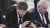 Chechen leader Ramzan Kadyrov (left) seems very attached to his cell phone and is an active Instagram user. (file photo)