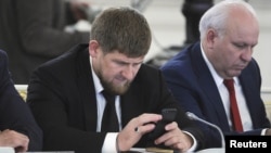 Chechen leader Ramzan Kadyrov (left) seems very attached to his cell phone and is an active Instagram user. (file photo)