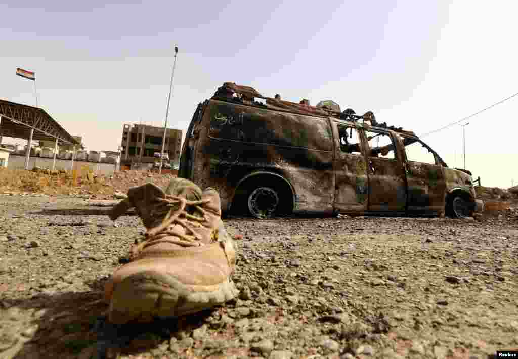 A burnt vehicle belonging to Iraqi security forces is pictured at a checkpoint in east Mosul, one day after radical Sunni Muslim insurgents seized control of the northern city, on June 11. (Reuters)