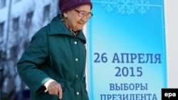 26 сәуір күні кезектен тыс президент сайлауы өтетіні туралы баннер жанынан өтіп бара жатқан әйел адам. Астана, 24 сәуір 2015 жыл.