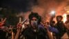 A protester wears tear gas canisters on his fingers and gestures the victory sign during anti-government protests in the Shiite shrine city of Karbala, south of Iraq's capital Baghdad, late on October 28, 2019.