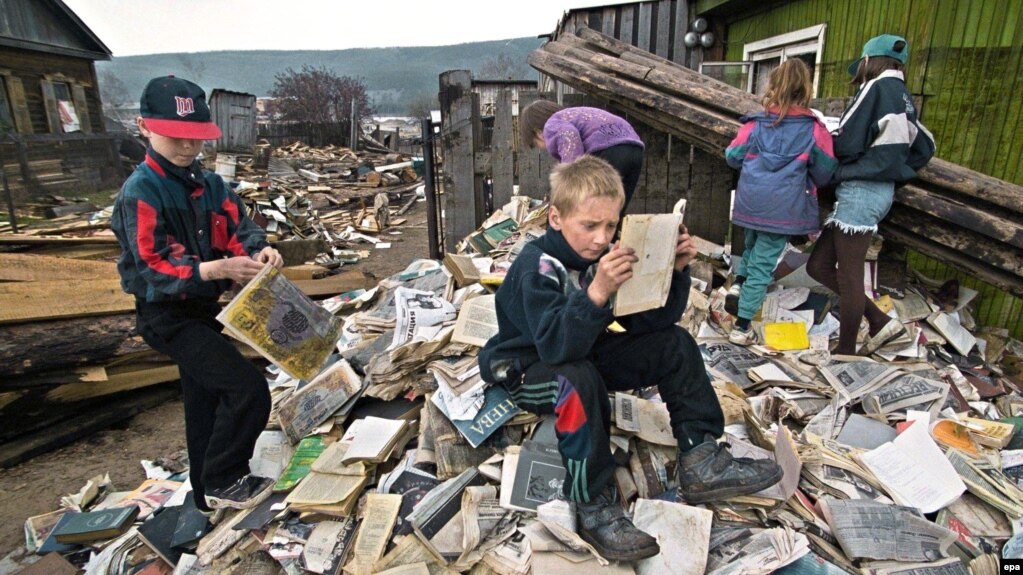 Дети на книгах и журналах из библиотеки, разрушенной наводнением. Ленск, 2001 год