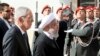 Austrian President Alexander Van Der Bellen, left, and Iranian President Hassan Rouhani attend a military welcome ceremony as part of a meeting in Vienna, Austria, Wednesday, July 4, 2018