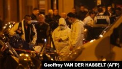 Forensic officers and French police stand in Monsigny Street in Paris after a man armed with a knife was shot dead by police in Paris on May 12.