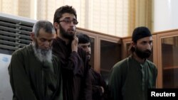 Four Afghan men look on in court during their trial in connection with the killing of a 27-year-old Farkhunda, in Kabul on May 6.