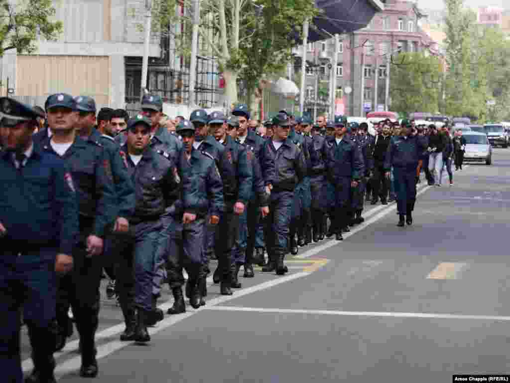 More than 100 police march alongside a protest led by Nikol Parshinian in Yerevan.