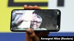 Director Mohammad Rasoulof, winner of the Golden Bear in Berlin for There Is No Evil, speaks through a video call as his daughter Baran Rasoulof holds up a smartphone during a news conference on February 29 after the awards ceremony.