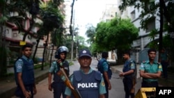 Bangladeshi policemen guard a check-point on a road block leading to the Holey Artisan Bakery, the scene of a fatal attack and siege, in Dhaka on July 3. 