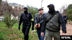 Russian officers detain Crimean Tatar activist Bekir Degermendzhi in Simferopol on November 23.