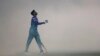 Indian cricketer Shreyas Iyer heads to practice at a sports ground covered with fumigation smoke ahead of a T20 match in New Delhi on April 4. (AP/Altaf Qadri)