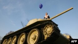 Девушка на танке, стоящем у Бранденбургских ворот в Берлине.