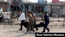 Afghan officials carry the dead body of a victim at the site of a suicide bomb attack near a Shi'ite mosque in Kabul on March 9. 