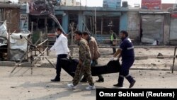 Afghan officials carry the dead body of a victim at the site of a suicide bomb attack near a Shi'ite mosque in Kabul on March 9.