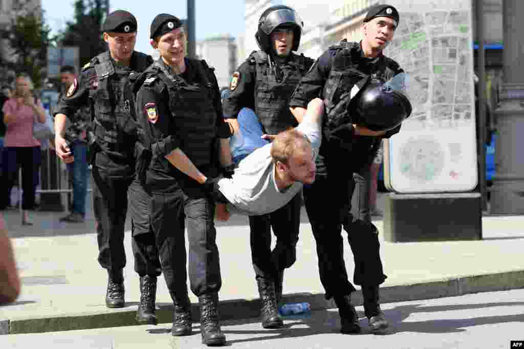 Russian police officers detain a man during an unauthorized opposition rally in Moscow on July 27. (AFP/Kirill Kudravtsev)&nbsp;